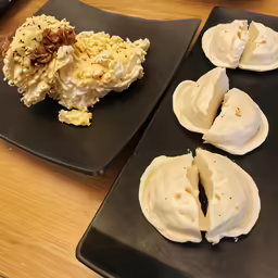 some kind of desserts on black plates on the table
