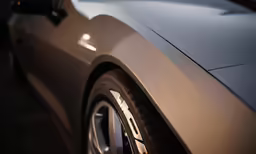 the side view of a car with white wheels and brake pads