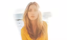 a woman standing near the water on a sunny day