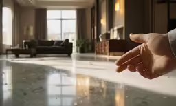a hand pointing in a large room at a living room table