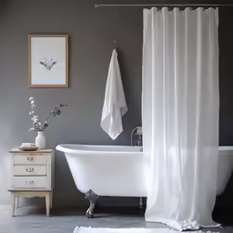 an old bath tub with a shower curtain hanging on the side