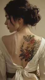 woman wearing tattoo with white dress looking off to the side