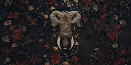 a person wearing a suit and tie laying on top of a toilet
