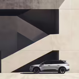 the volvo suv is parked next to a large building