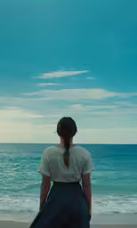 the woman is looking out into the water