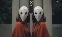 a woman in a red dress and mask in a hallway