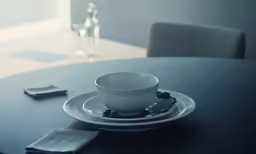 a table with plates, silver napkins, glasses and bottles