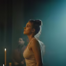 a person standing in front of a candle with two people behind it