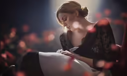 a woman in a black and white dress is holding a flower