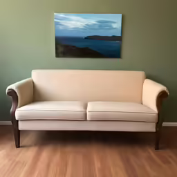 a room with a couch and a painting on the wall