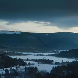 landscape of mountains, trees and a body of water