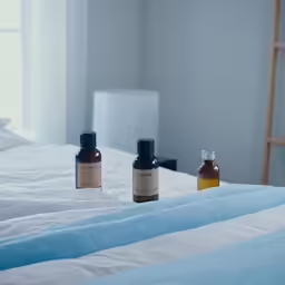 three bottles of the same product are sitting on the bed