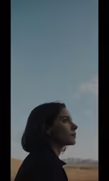 a girl with a dark coat looking back