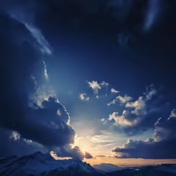 a dark sky with fluffy white clouds and some bright sun