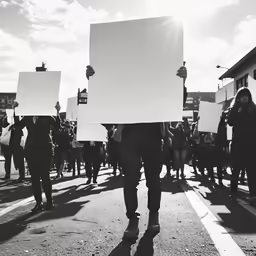 a group of people carrying signs walking down a street