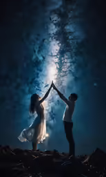 two people hold hands under the stars at night