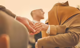 a person in a business suit holds a mans hands