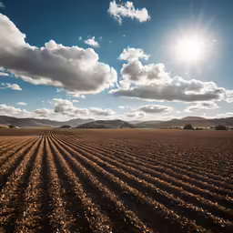 the sky is full of clouds as the sun shines on an empty field