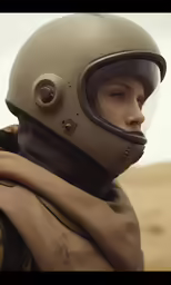a young man wearing a motorcycle helmet and a scarf