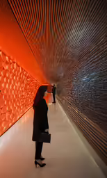 woman waiting at the entrance to a building with a colorful wall
