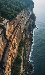 a train traveling along the coast with rocky shore
