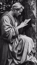 a man in robes is leaning on a tree