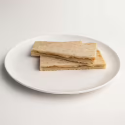 small crackers sit on a white plate on a white table
