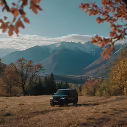 the front end of a black suv on a field