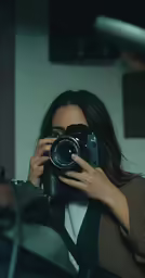 a woman taking pictures with a camera of something