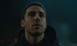 a man looking away into the distance in the dark