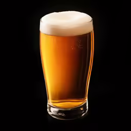 beer on a dark black background in a glass