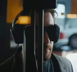 a man with headphones on looks through a display of electronic equipment