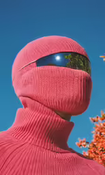 a person wearing sunglasses and a pink knitted coat