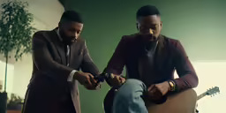 two men holding guitars while one man checks his watch