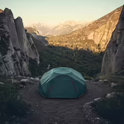 tent in front of mountains and trees with rocky terrain