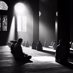 a black and white photograph of several men sitting on the floor