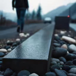 a person walking down a road next to rocks