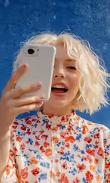 a woman holds up a cell phone to take a picture