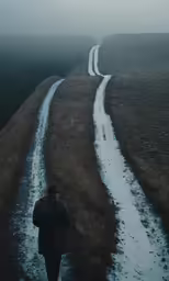 a man is walking down a snowy road