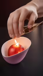 hand lighting candle for small bowl filled with fruit