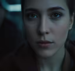 a woman with dark blue eyes stares into the distance