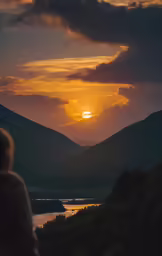 the sun rising over the mountains on top of a hill