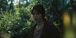 a young woman standing next to the woods looking angry