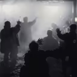 people stand around a crowd of white smoke