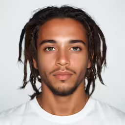 a man in white t - shirt with black dreadlocks on