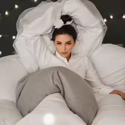 a young woman is lying on a bed