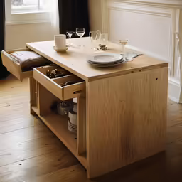 the kitchen table with its open drawers is sitting in the middle of the room
