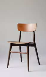 a pair of wooden chairs on grey background