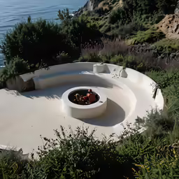 an outdoor concrete fire pit with a small circular fire