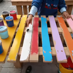 man painting outside furniture using paint colors